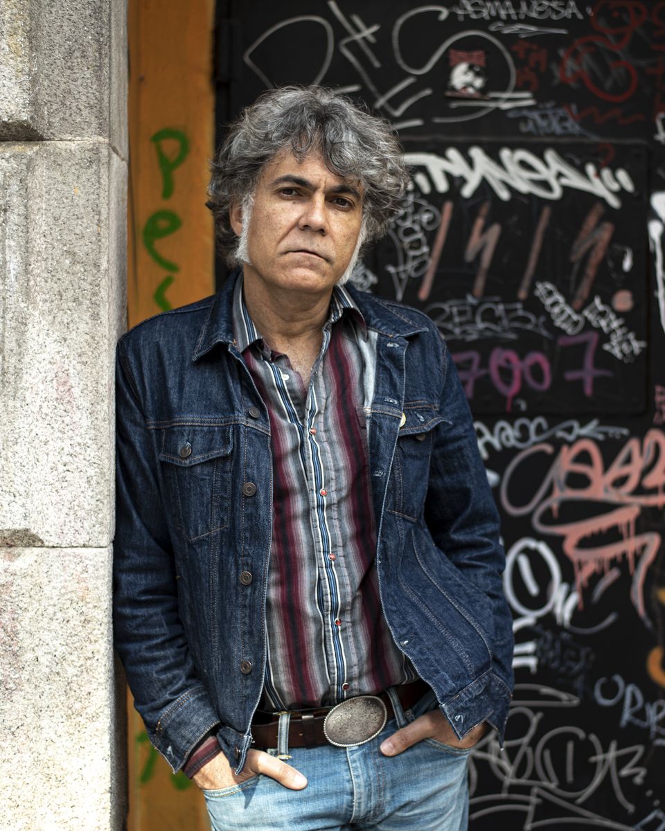Oscar Avendaño apoiado nunha porta chea de grafitis
